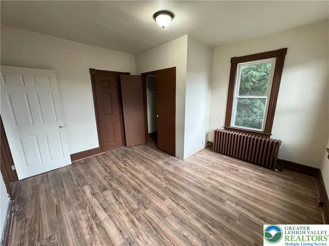 a view of a room with wooden floor and window