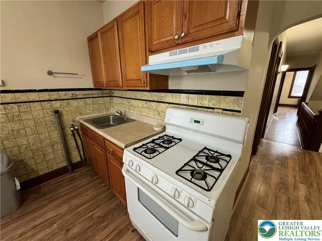 a kitchen with granite countertop a stove and a sink