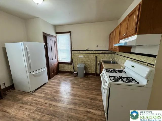 a kitchen with refrigerator and white cabinets