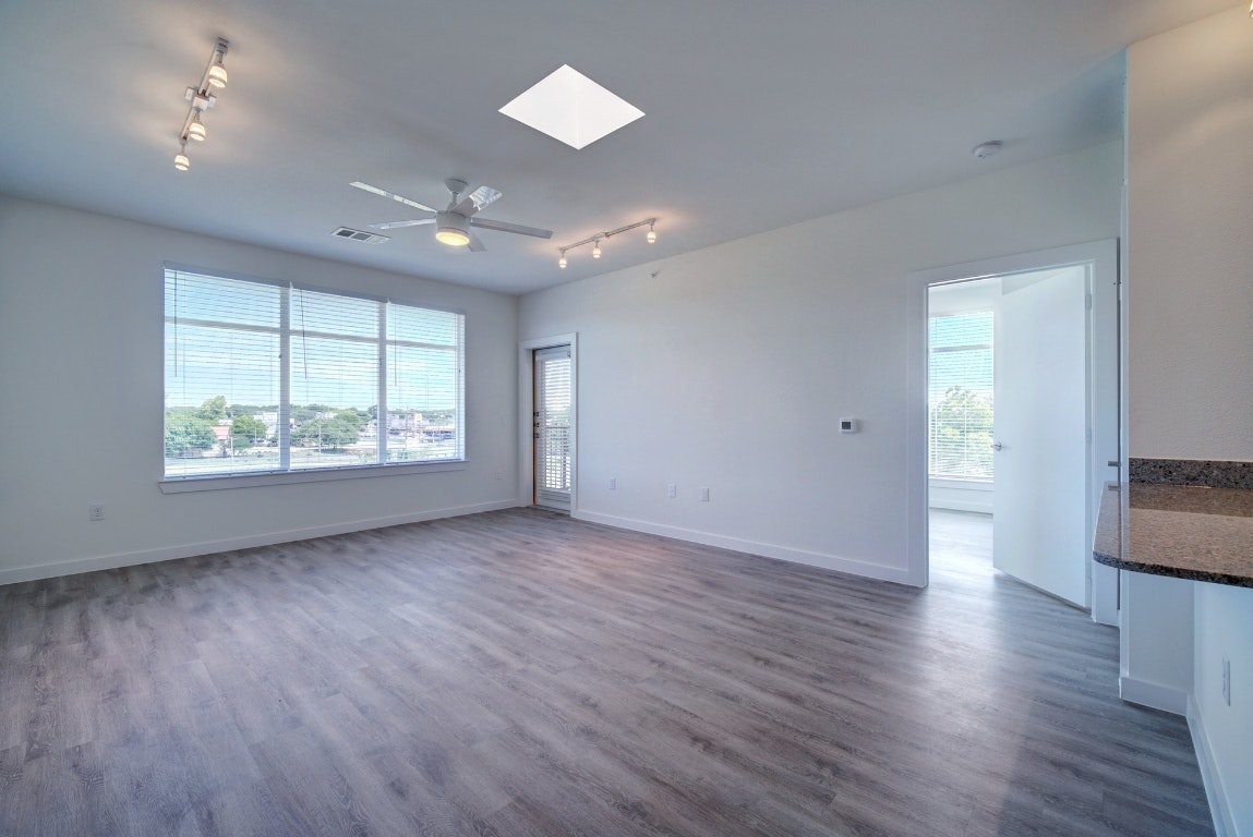 13130 Pond Springs Road, Unit 3212 Austin, TX 78750 - Photo 9 of 33 an empty room with wooden floor and windows