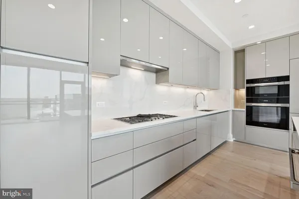 a kitchen with stainless steel appliances a stove a sink and a refrigerator