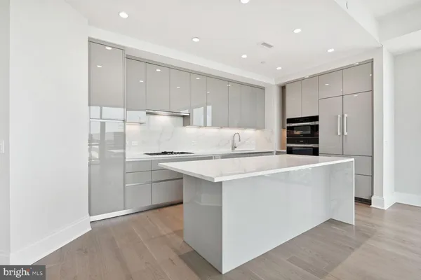 a kitchen with stainless steel appliances granite countertop a white stove top oven and white cabinets