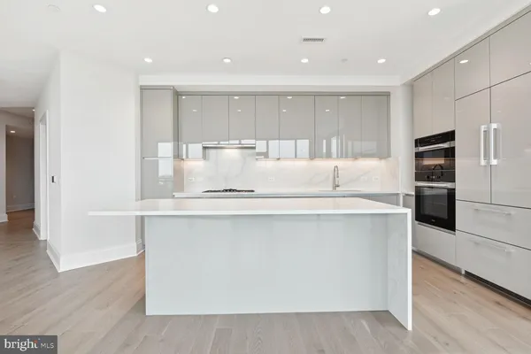 a view of a kitchen with center island and stainless steel appliances