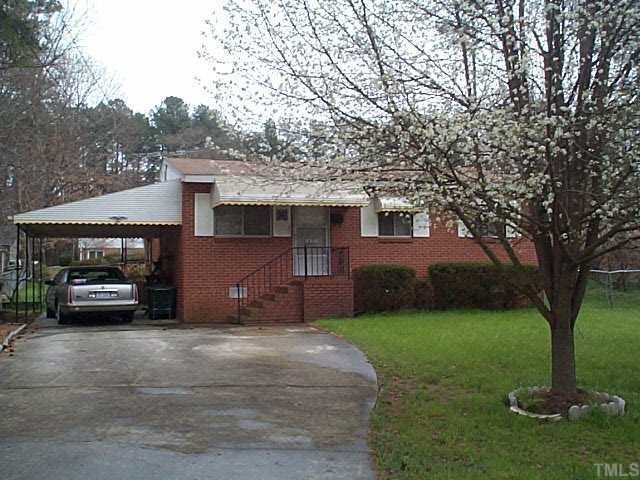 a view of a house with a cars park next to a road