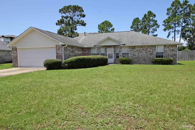 a front view of a house with a garden and yard