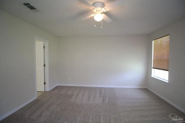 an empty room with a window and a fan