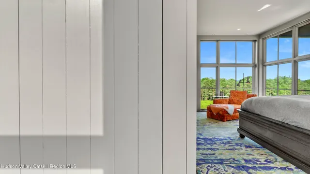 a bedroom with furniture and a large window