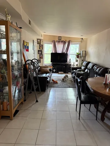 a living room with furniture a flat screen tv and a window