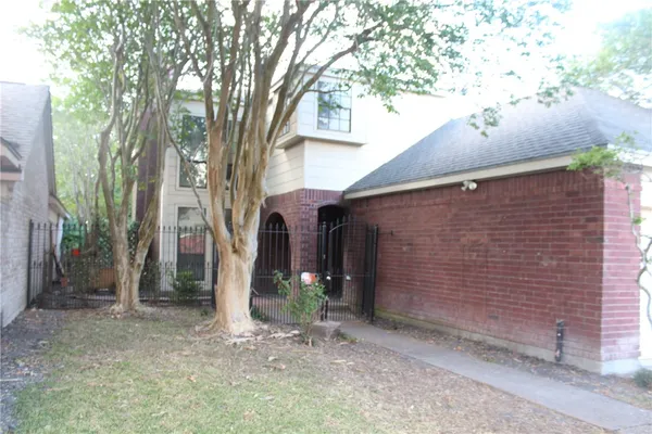 a view of a house with a tree and a yard