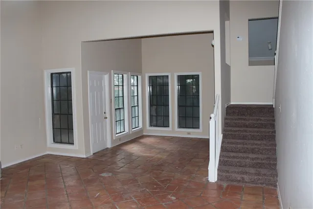 a view of a big room with stairs and a living room