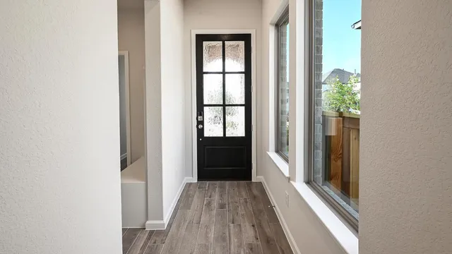 a view of a hallway with wooden floor and stairs