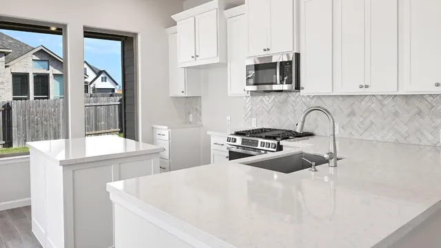 a kitchen with stainless steel appliances a sink a stove and cabinets