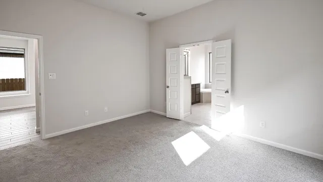 a view of an empty room and a bathroom