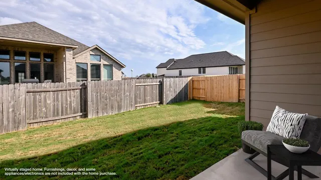 a view of backyard with small cabin and wooden fence