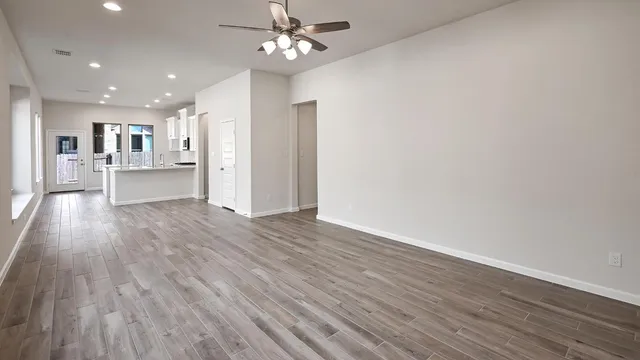 a view of a kitchen with wooden floor and a ceiling fan
