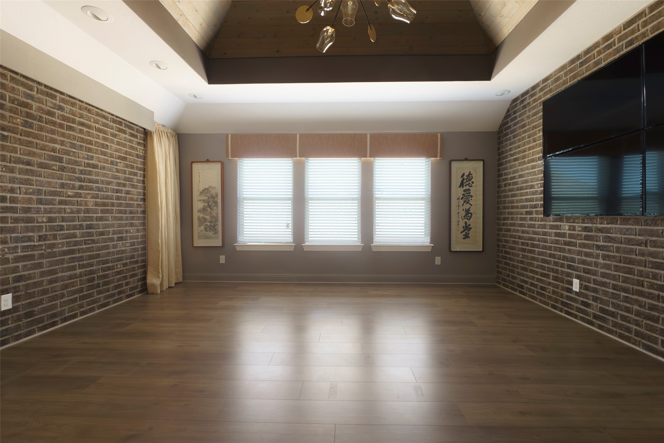 2305 Millbrook Loop Leander, TX 78641 - Photo 9 of 26 Refined wood flooring complements rustic brick accent walls in this versatile living space.