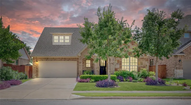 a front view of a house with a yard and a garage
