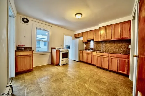 a kitchen with granite countertop a sink cabinets and stainless steel appliances