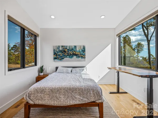 a bedroom with a balcony a bed and a painting on the wall