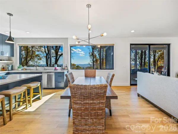 a living room with furniture a large window and kitchen view
