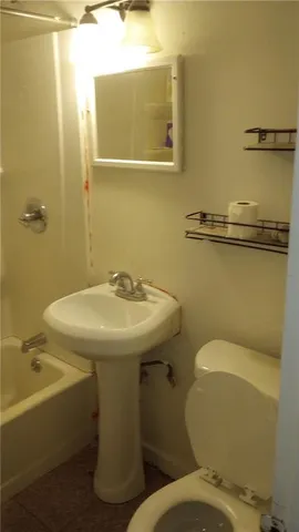 a bathroom with a sink and mirror with toilet