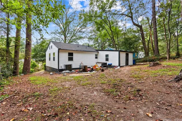 a view of a house with backyard and trees