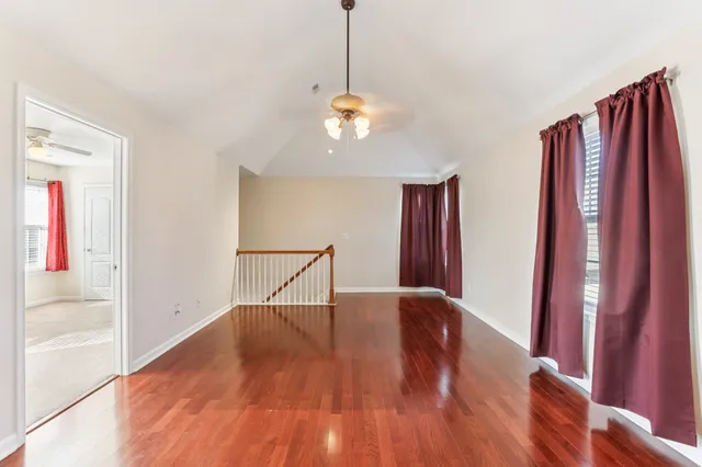 a view of a livingroom with wooden floor and a ceiling fan