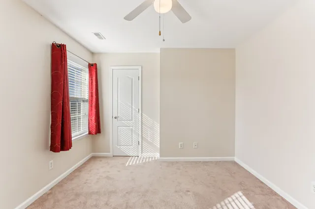 a view of a room with a ceiling fan and a window