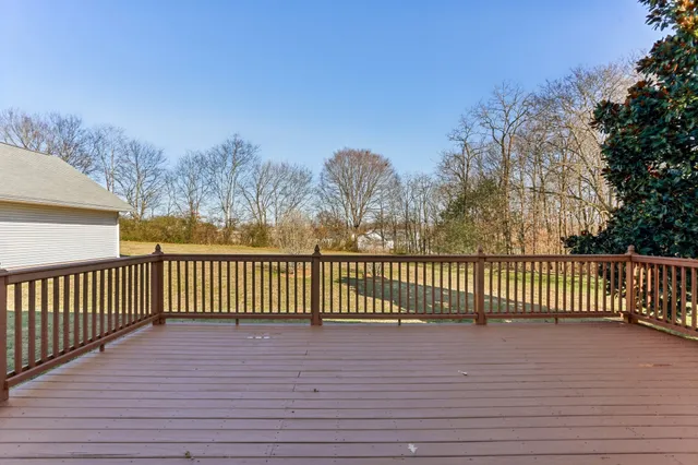 a view of a wooden deck with a yard and wooden fence