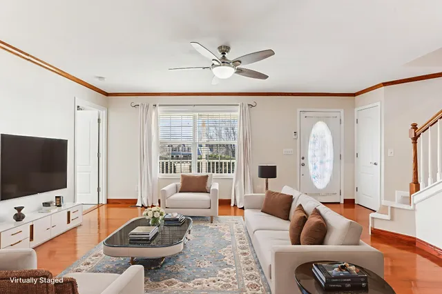 a living room with furniture a flat screen tv and a large window