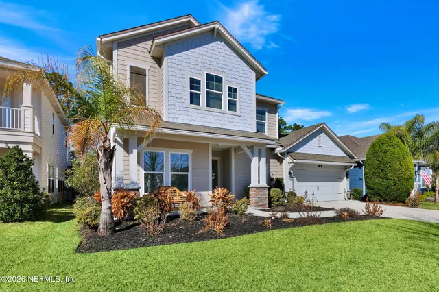 a front view of a house with a yard and potted plants