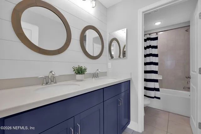 an aerial view of a city with lots of residential buildings ocean and mountain view in back