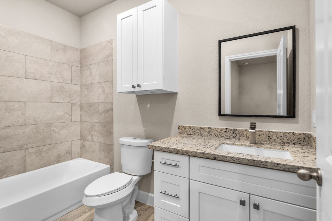 496 Golden Street, Unit A Willis, TX 77378 - Photo 12 of 26 a bathroom with a granite countertop toilet sink and mirror