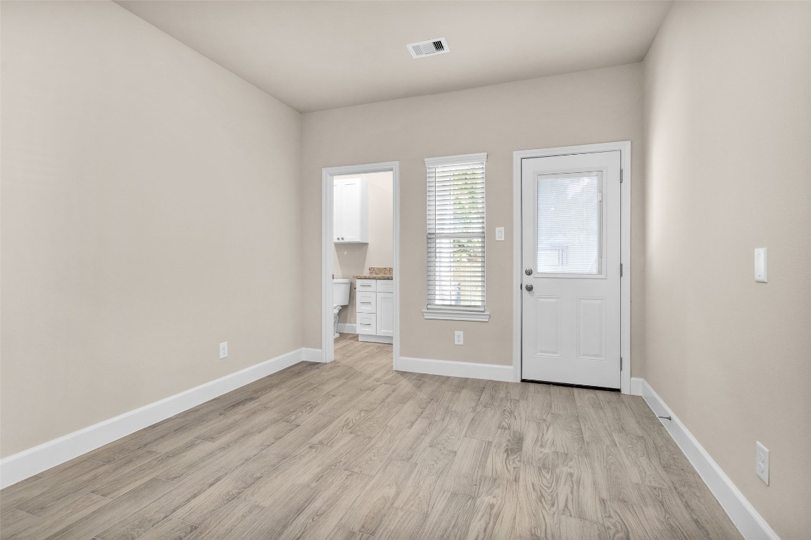 496 Golden Street, Unit A Willis, TX 77378 - Photo 15 of 26 an empty room with wooden floor and windows