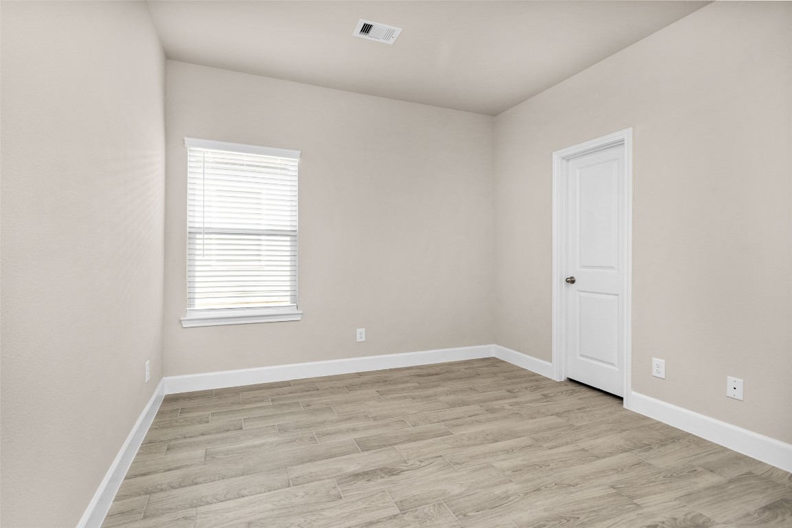 496 Golden Street, Unit A Willis, TX 77378 - Photo 17 of 26 an empty room with wooden floor and windows
