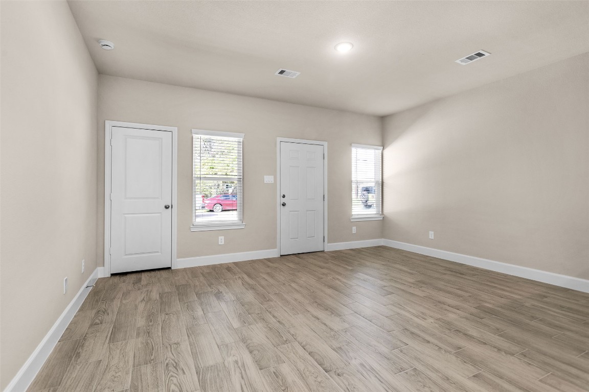 496 Golden Street, Unit A Willis, TX 77378 - Photo 22 of 26 an empty room with wooden floor and windows