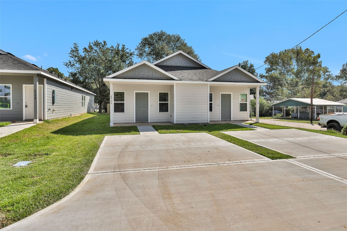496 Golden Street, Unit A Willis, TX 77378 - Photo 3 of 26 a front view of a house with a garden and yard