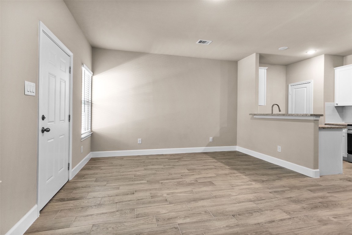496 Golden Street, Unit A Willis, TX 77378 - Photo 6 of 26 wooden floor in an empty room with a window