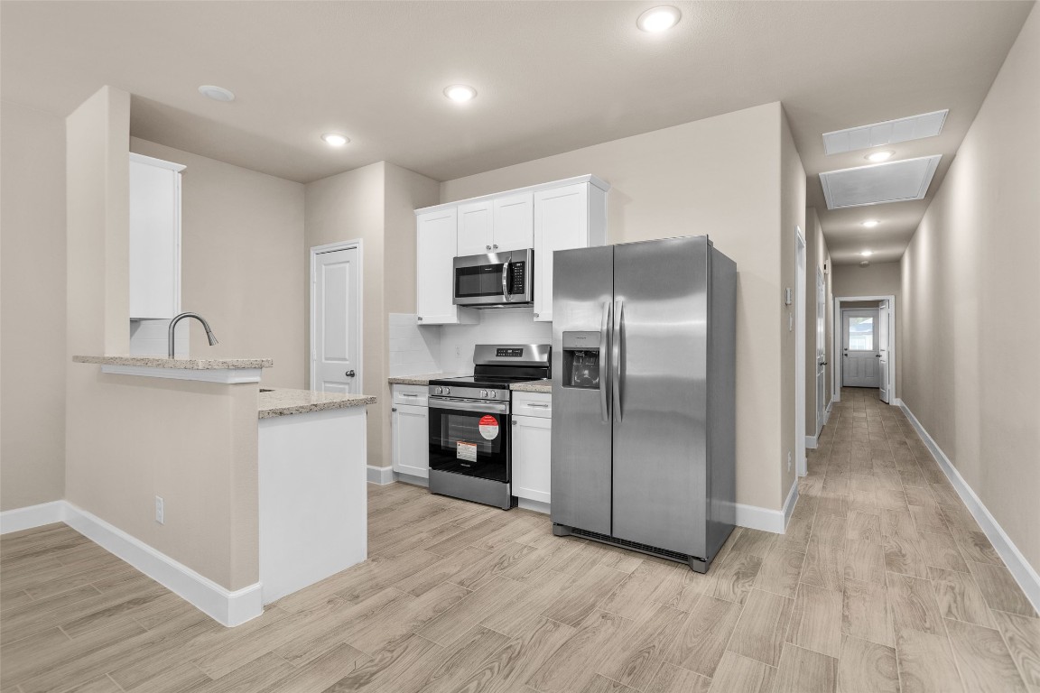 496 Golden Street, Unit A Willis, TX 77378 - Photo 7 of 26 a kitchen with granite countertop a refrigerator and a sink