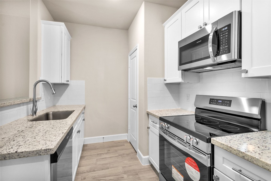 496 Golden Street, Unit A Willis, TX 77378 - Photo 9 of 26 a kitchen with a stove and a microwave