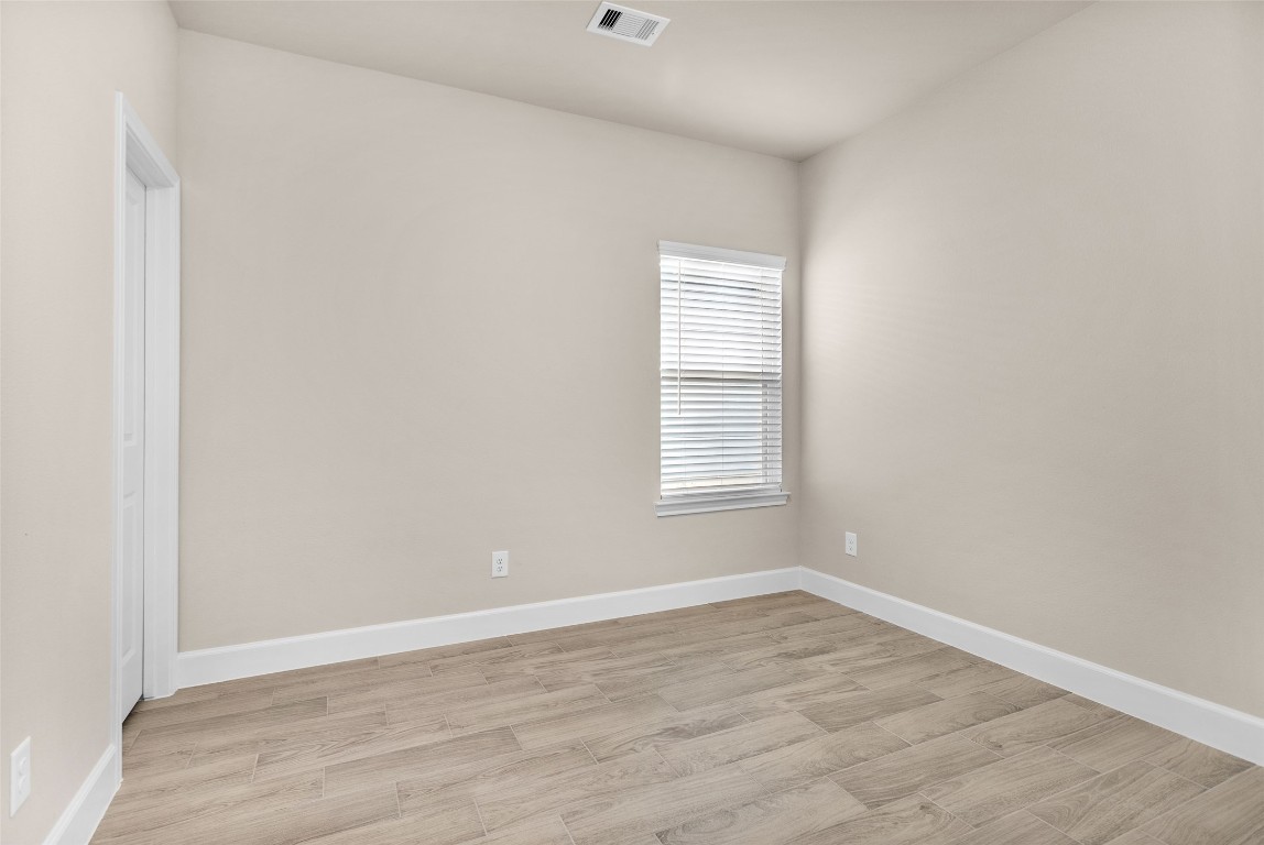 496 Golden Street, Unit A Willis, TX 77378 - Photo 10 of 26 an empty room with wooden floor and windows