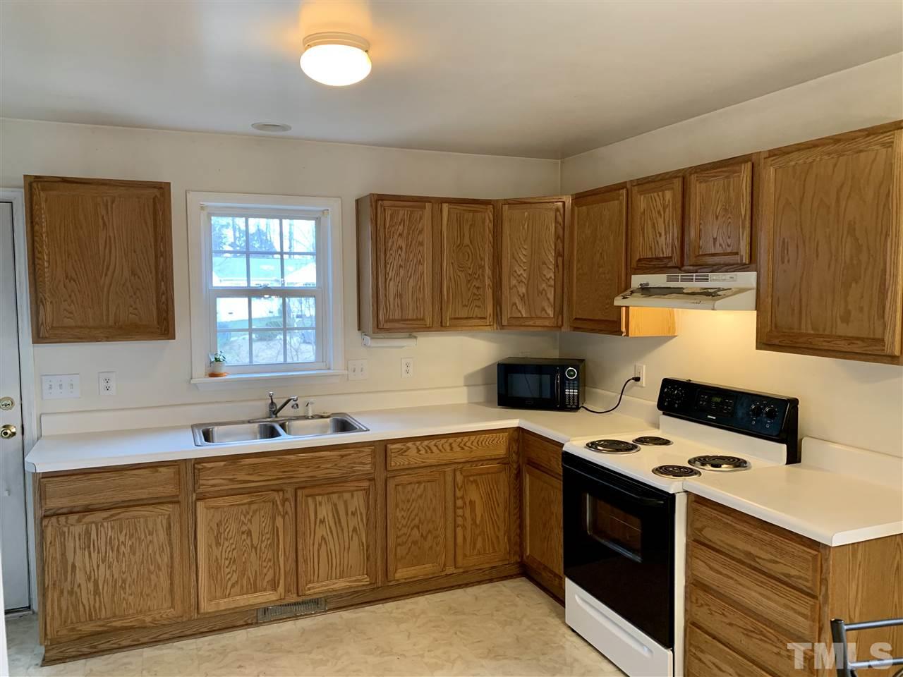 1117 Thelonious Drive Raleigh, NC 27610 - Photo 14 of 25 a kitchen with kitchen island granite countertop a sink cabinets and stainless steel appliances