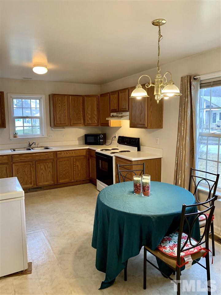 1117 Thelonious Drive Raleigh, NC 27610 - Photo 17 of 25 a kitchen with a dining table chairs and white cabinets