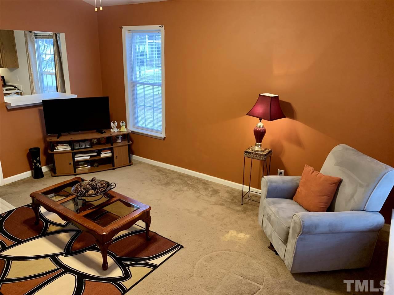 1117 Thelonious Drive Raleigh, NC 27610 - Photo 3 of 25 a living room with furniture a flat screen tv and a window