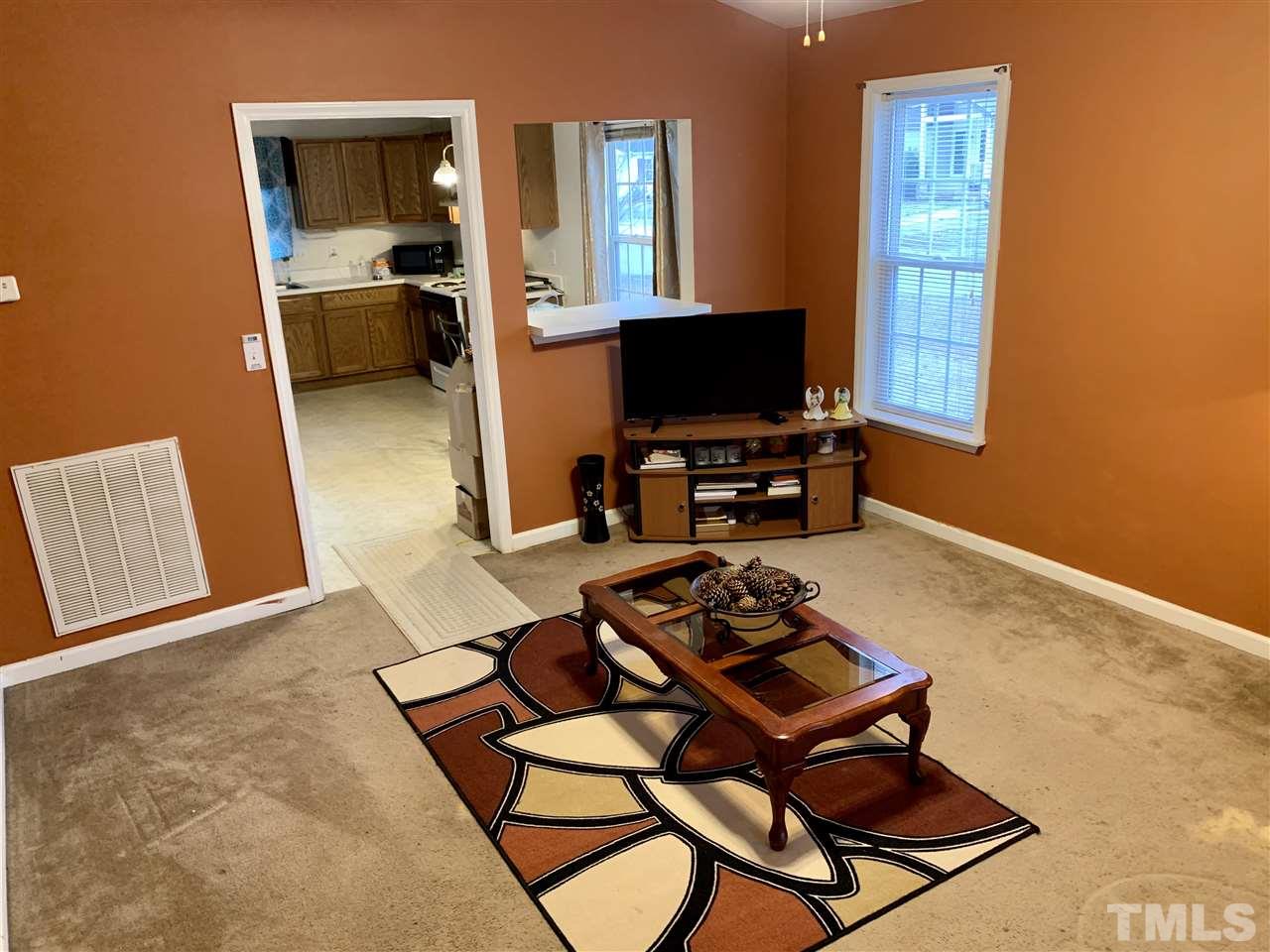 1117 Thelonious Drive Raleigh, NC 27610 - Photo 4 of 25 a living room with furniture a flat screen tv and a window