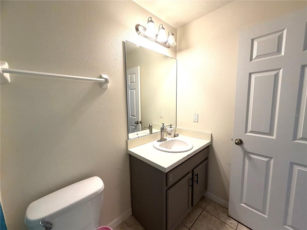 4573 Ada Lane Kissimmee, FL 34746 - Photo 15 of 37 a bathroom with a sink vanity mirror and toilet
