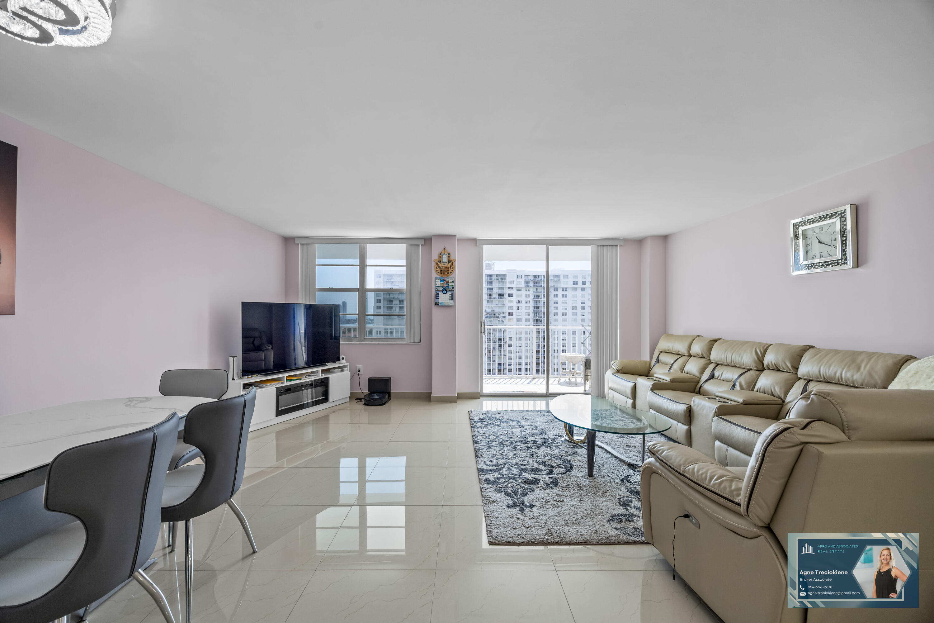 2801 Northeast 183rd Street, Unit 1606W Aventura, FL 33160 - Photo 2 of 53 a living room with furniture a flat screen tv and a floor to ceiling window