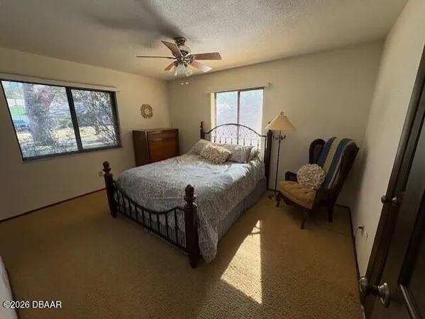 a bedroom with a bed chair and window