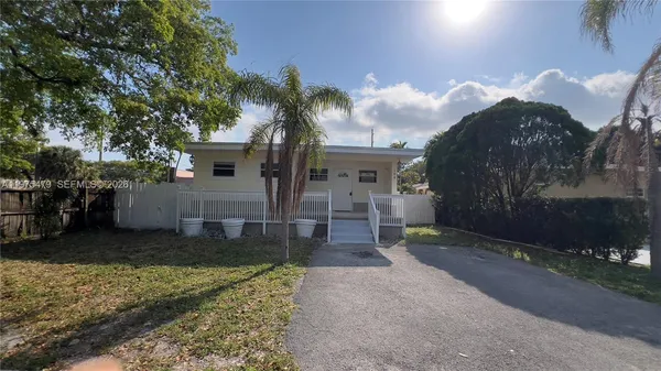 a view of a house with a yard and tree