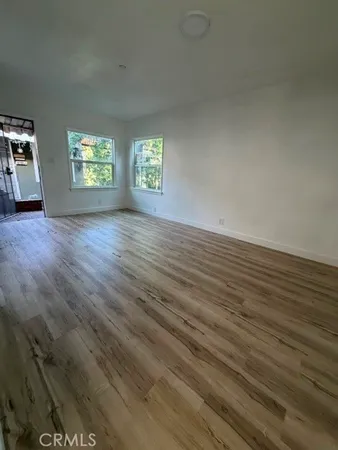 an empty room with wooden floor and a window